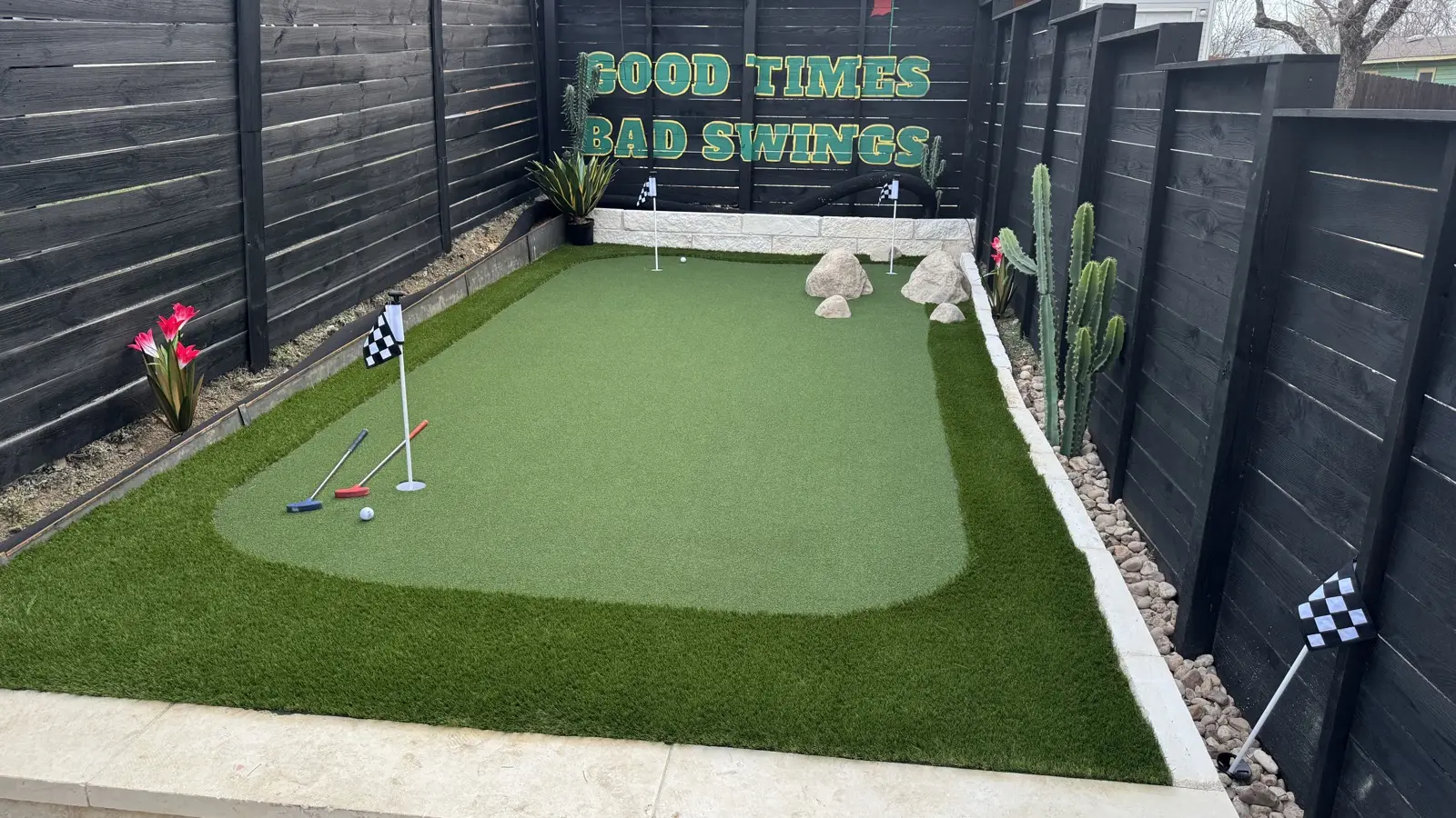 After: finished backyard putting green with stone border and landscaping